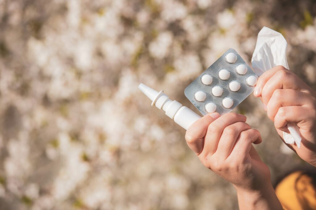Allergiemedicatie en zakdoek in handen, als reactie op allergieën en hormonale verstoringen.